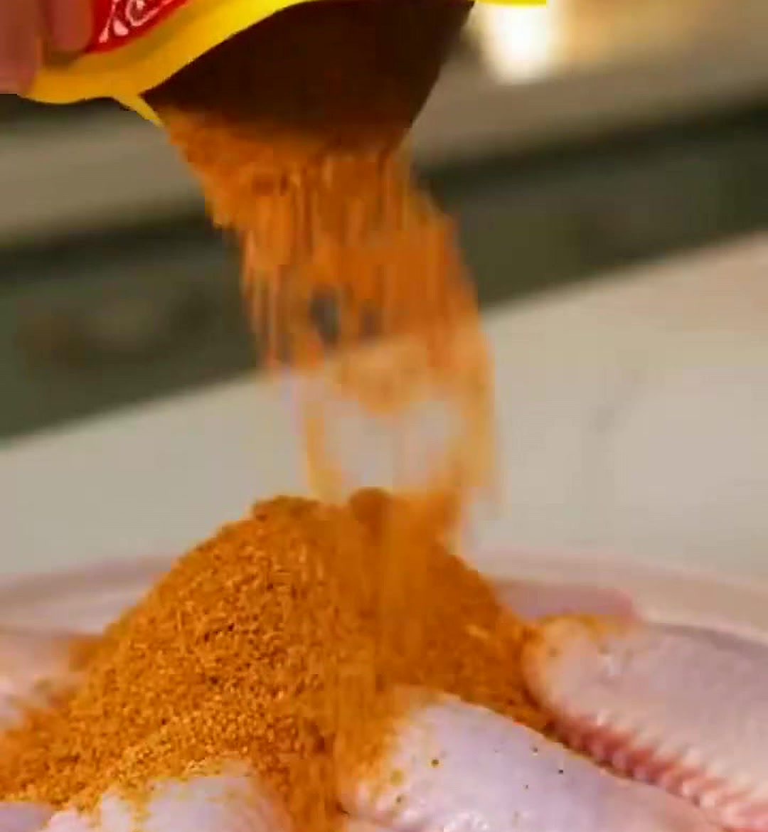 黄袋倾倒橙红腌料粉至生鸡翅