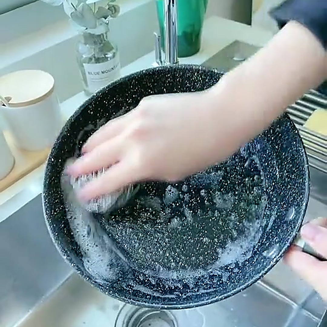 泡沫刷洗麦饭石不粘锅特写,展示清洁力